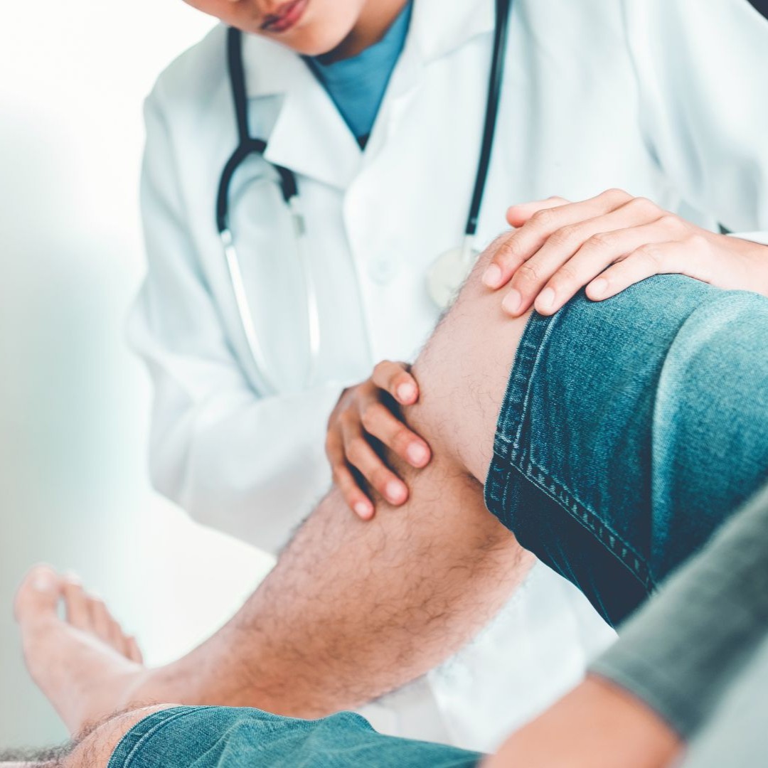 Doctor examining a patient’s knee during an orthopaedic evaluation for knee pain in Amherst, NY.
