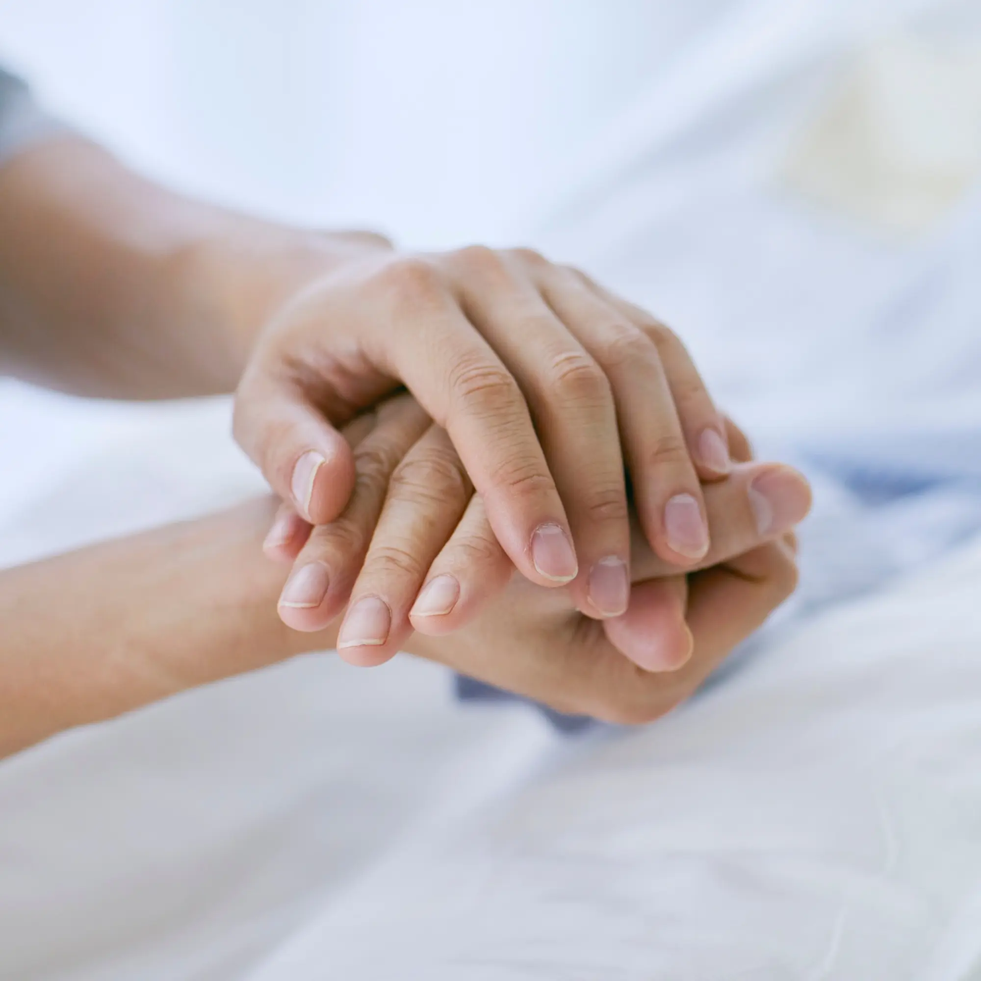 Caregiver holding a patient's hand in a reassuring gesture during orthopaedic care in Hamburg, NY